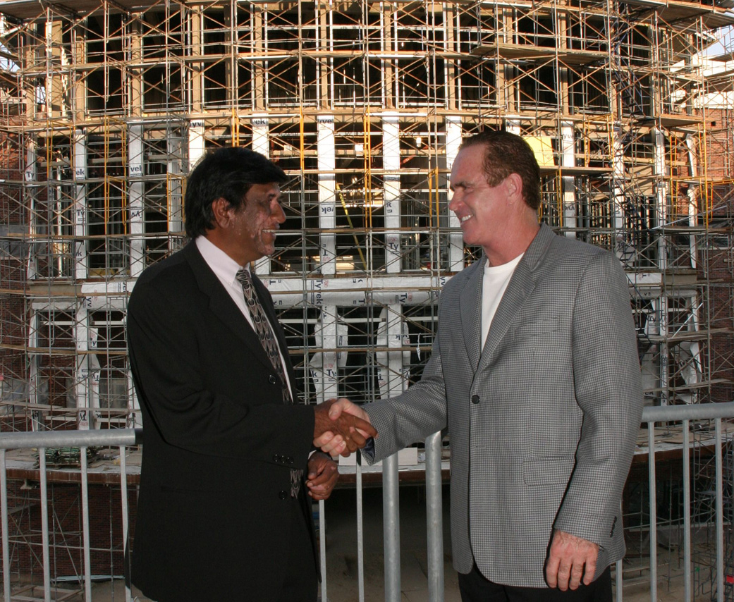 Tom Pepin and Dr. Patel shake hands outside of the T. Pepin's Hospitality Centre during construction in 2006