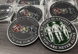 Graduates designed a custom challenge coin that reads First to Respond, Last to Ask for Help (Front) & We Fight as a Family, You Are Never Alone (Back). Each coin includes a QR code linking to a current list of vetted mental health resources.